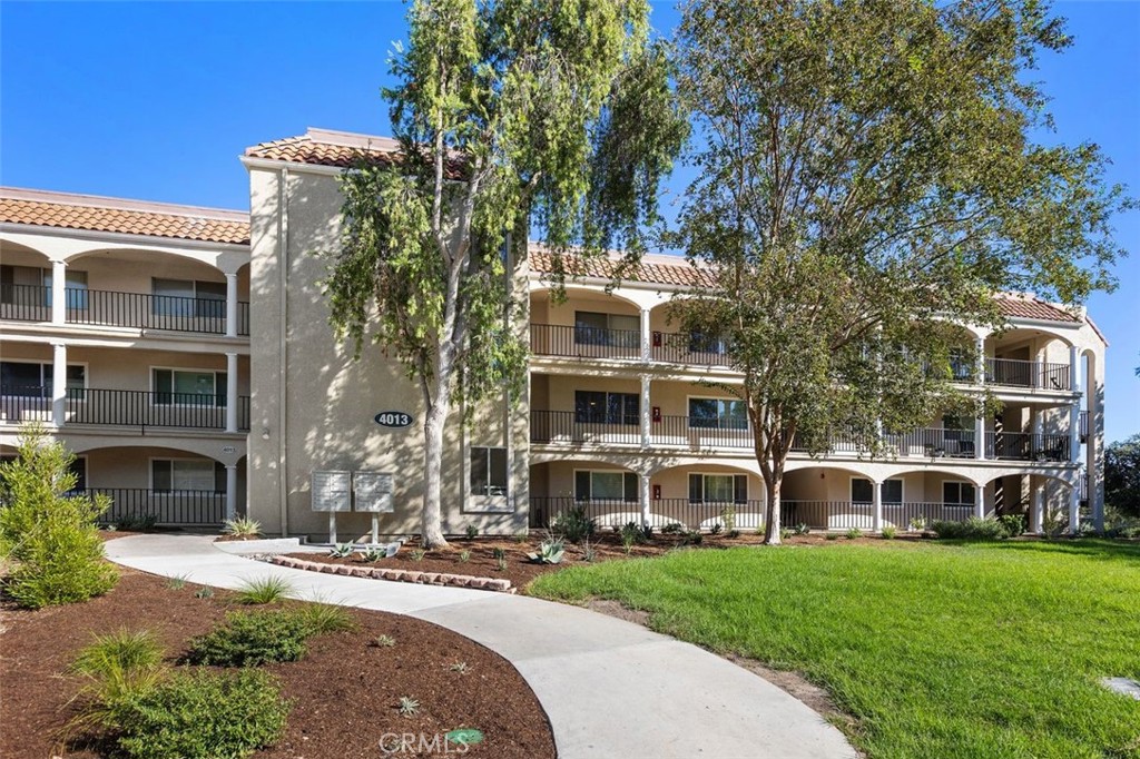 Lovely, manicured grounds greet you outside of the well-maintained building that features an elevator. - 4013 Calle Sonora Oeste Unit 2E, Laguna Woods CA 92637 - photo 2