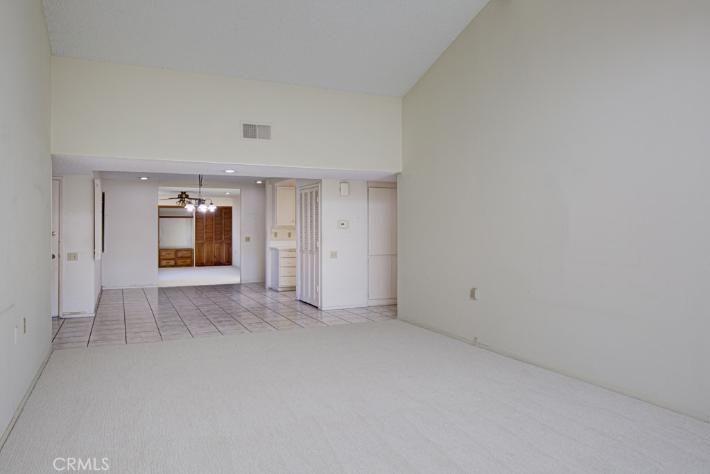 Another view of the living room looking back towards the dining area and bonus room in the background. - 5380 Avenida Sosiega B, Laguna Woods CA 92637 - photo 5