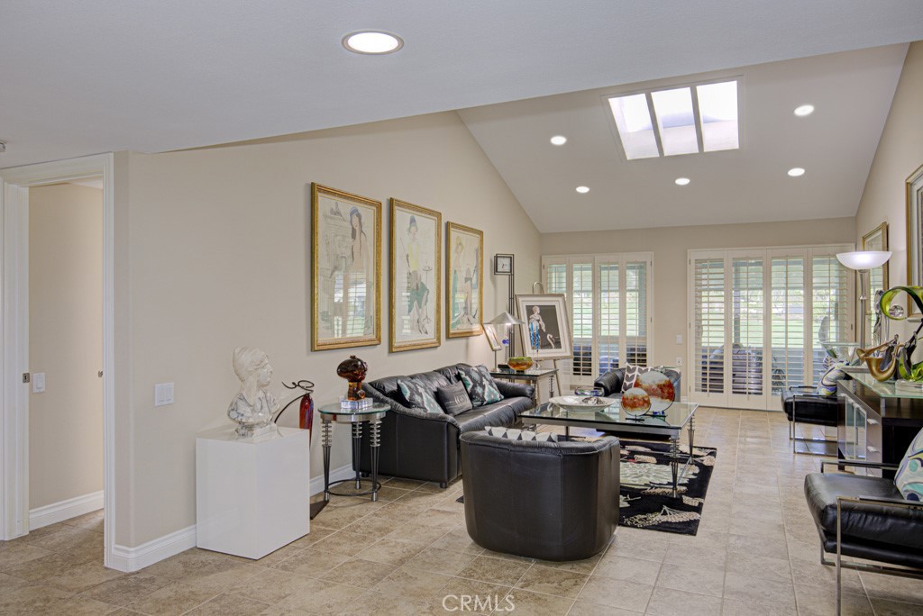 Living room as seen from the entry. Note the cathedral ceiling and skylights. Enclosed rear patio can be access via the - 5516 Paseo Del Lago W A, Laguna Woods CA 92637 - photo 3