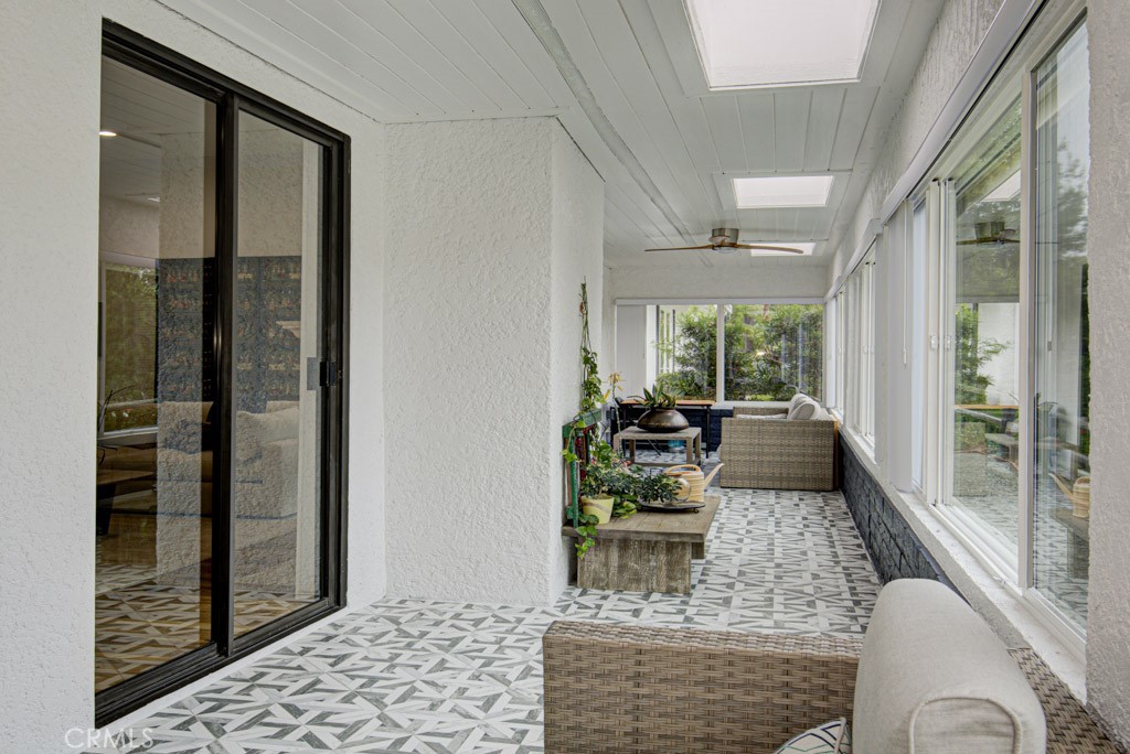 Enclosed and covered rear patio has skylights and ceiling fans and extends the length of the residence. - 5553 Rayo Del Sol B, Laguna Woods CA 92637 - photo 13