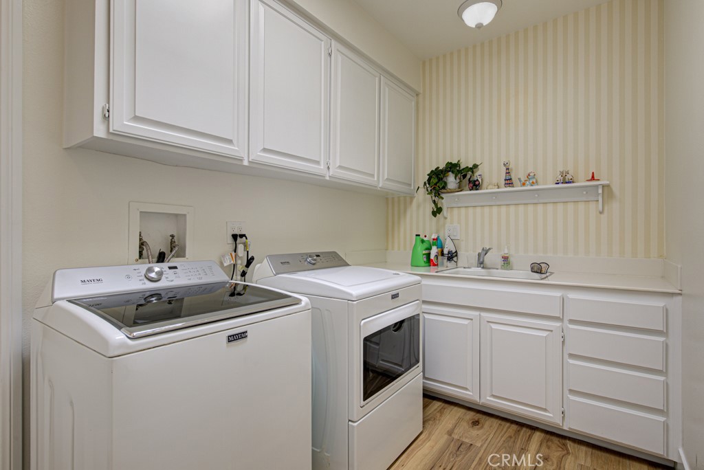 Separate laundry room features cabinet storage and utility sink. - 5553 Rayo Del Sol B, Laguna Woods CA 92637 - photo 40
