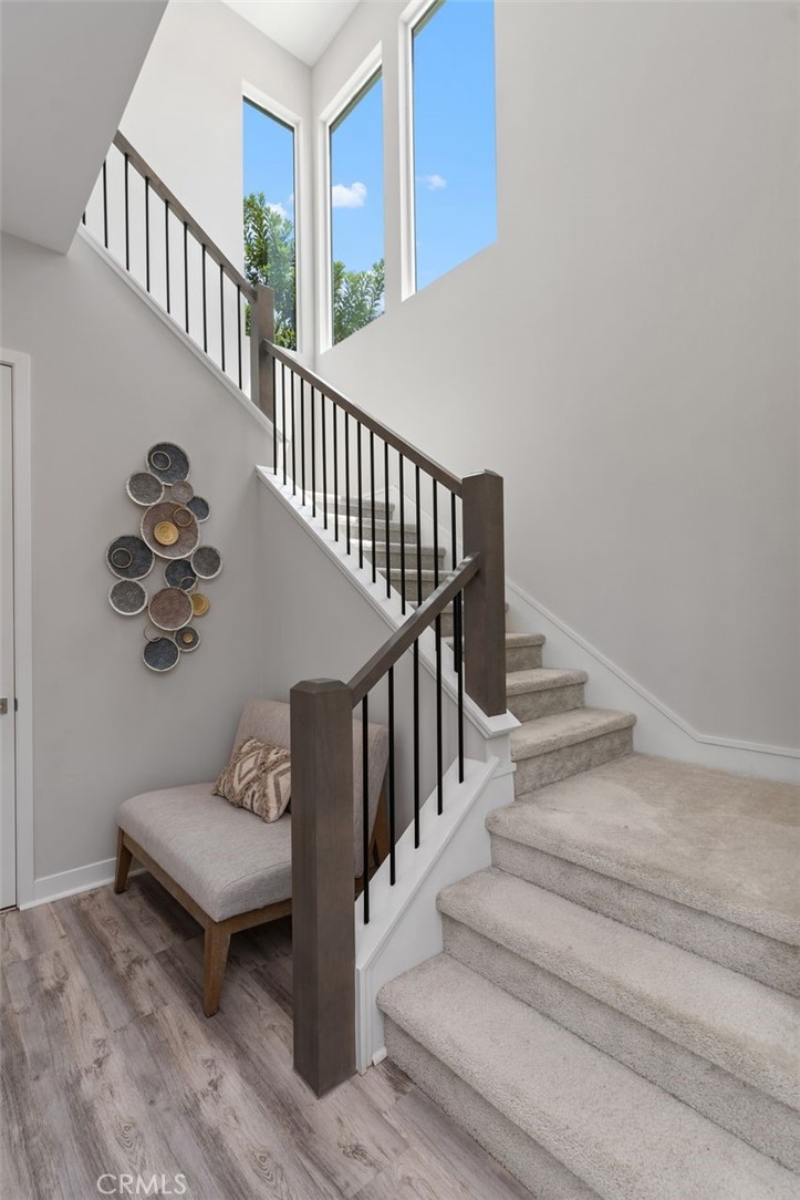 A striking architectural staircase is framed by expansive windows, filling the stairway with beautiful natural light. - 111 Edna Parkway, Lake Forest CA 92630 - photo 20
