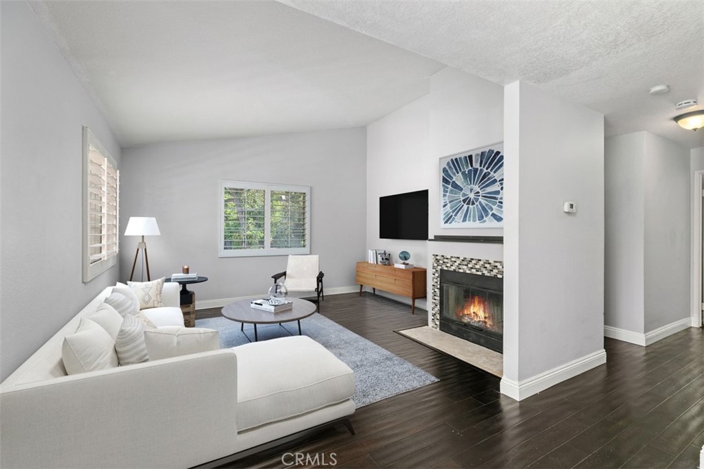 Virtually staged living room featuring high ceilings and an open, airy layout. - 21227 Camelia 18, Lake Forest CA 92630 - photo 2
