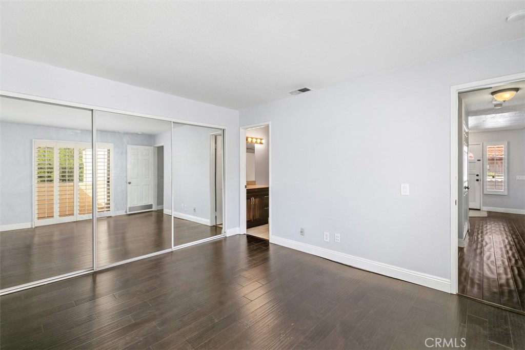 Primary bedroom with wall length closet and bathroom. - 21227 Camelia 18, Lake Forest CA 92630 - photo 12