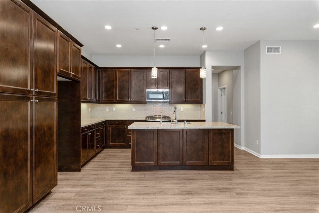 Open concept kitchen with oversized island and pendant lighting! - 219 Primrose Drive, Lake Forest CA 92610 - photo 9