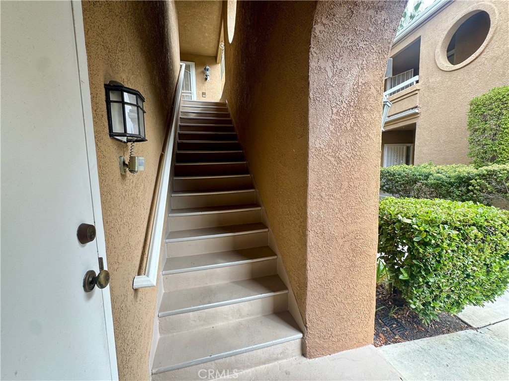 Stairway to front door. Garage access door. - 22854 Sailwind, Lake Forest CA 92630 - photo 5