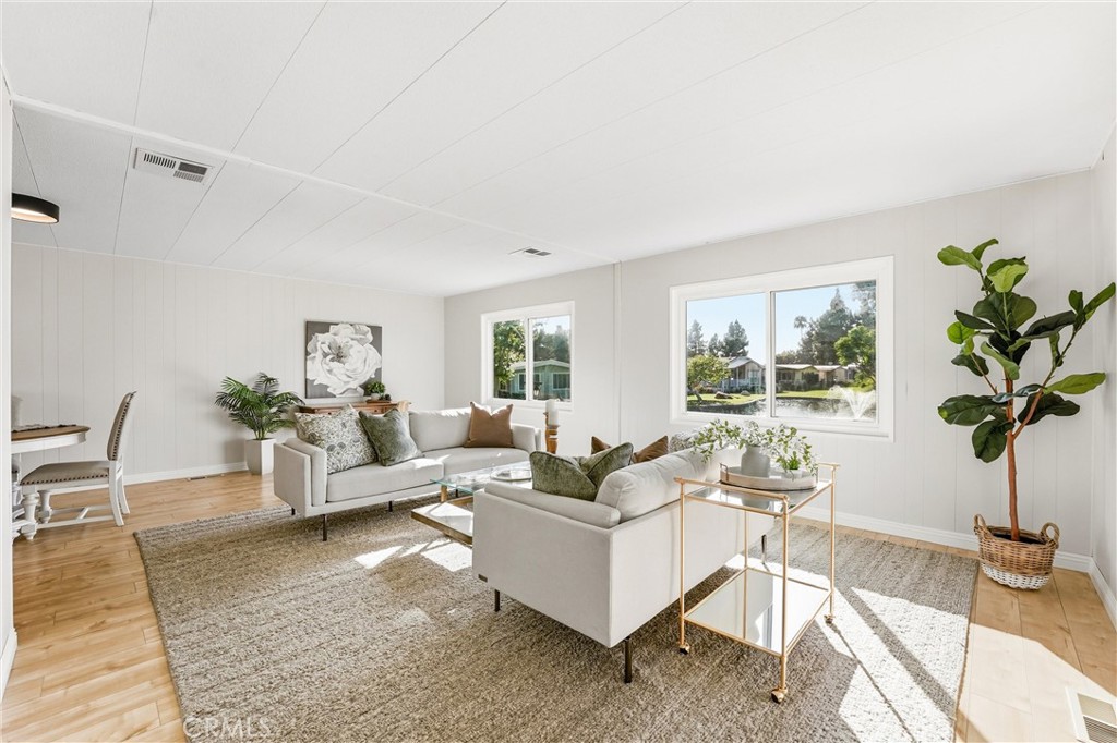 Living room with views of water - 24001 Muirlands Boulevard 64, Lake Forest CA 92630 - photo 9