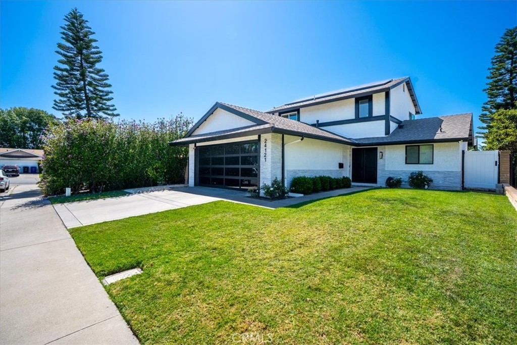 Front view of a two-story home from a left-angle perspective, highlighting the two-car garage and landscaped lawn. - 24121 Fortune Drive, Lake Forest CA 92630 - photo 1