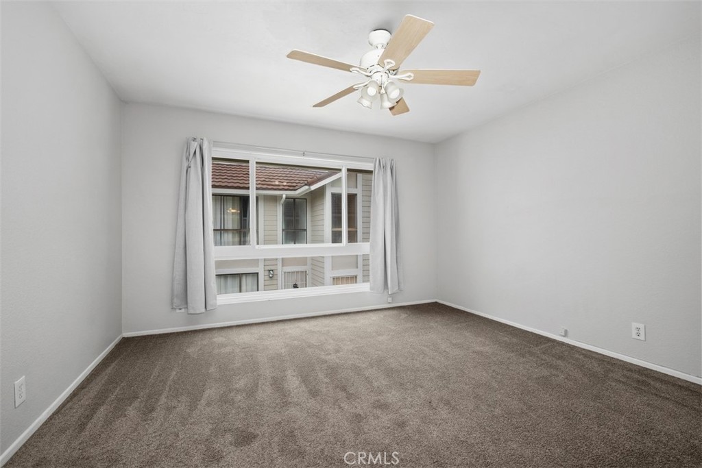 This is the front bedroom with ceiling fan and walk-in closet - 25885 Trabuco 16, Lake Forest CA 92630 - photo 5