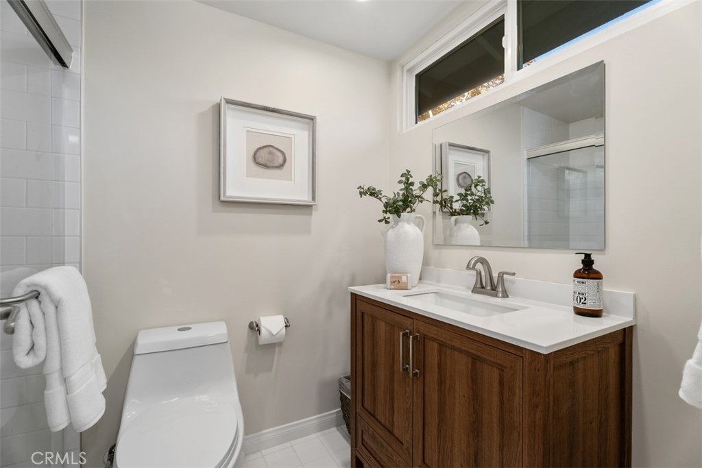 En-suite Primary Bath: newly remodeled with white subway tile, glass shower doors and decorative vanity. - 11772 Paseo Bonita, Los Alamitos CA 90720 - photo 23