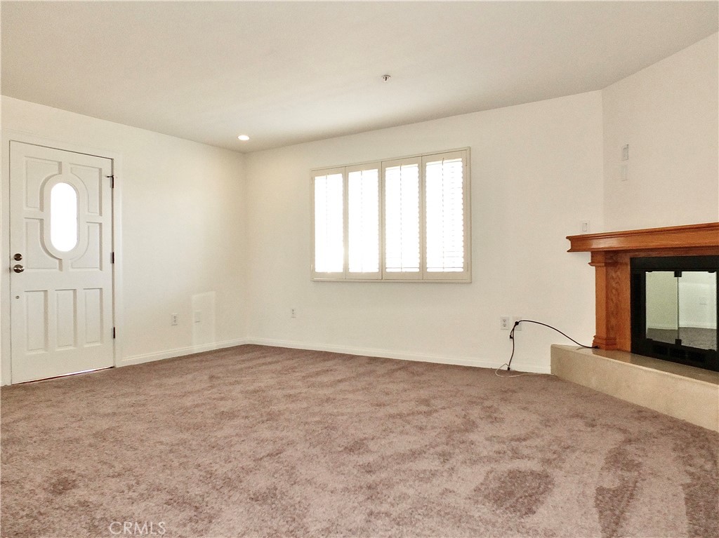 View of spacious living room with gas fireplace with pushbutton starter, window with shutters, recessed lighting and new - 4441 Farquhar, Los Alamitos CA 90720 - photo 7