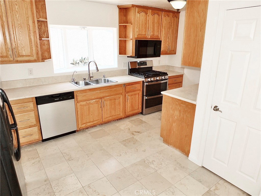 The kitchen offers generous counter space, a large pantry, a side-by-side refrigerator with a water line, built in range - 4441 Farquhar, Los Alamitos CA 90720 - photo 14