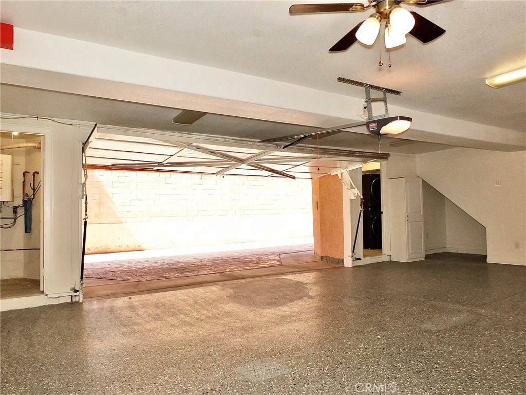Another view of the spacious finished garage shows the newer tankless water heater room, epoxy flooring and separate lar - 4441 Farquhar, Los Alamitos CA 90720 - photo 25