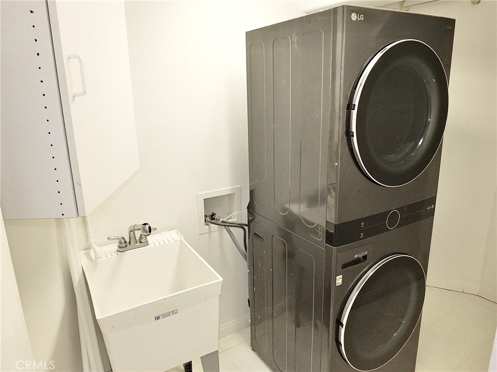 Laundry room with stacked washer and dryer, utility sink and storage cabinet included in sale. - 4441 Farquhar, Los Alamitos CA 90720 - photo 26
