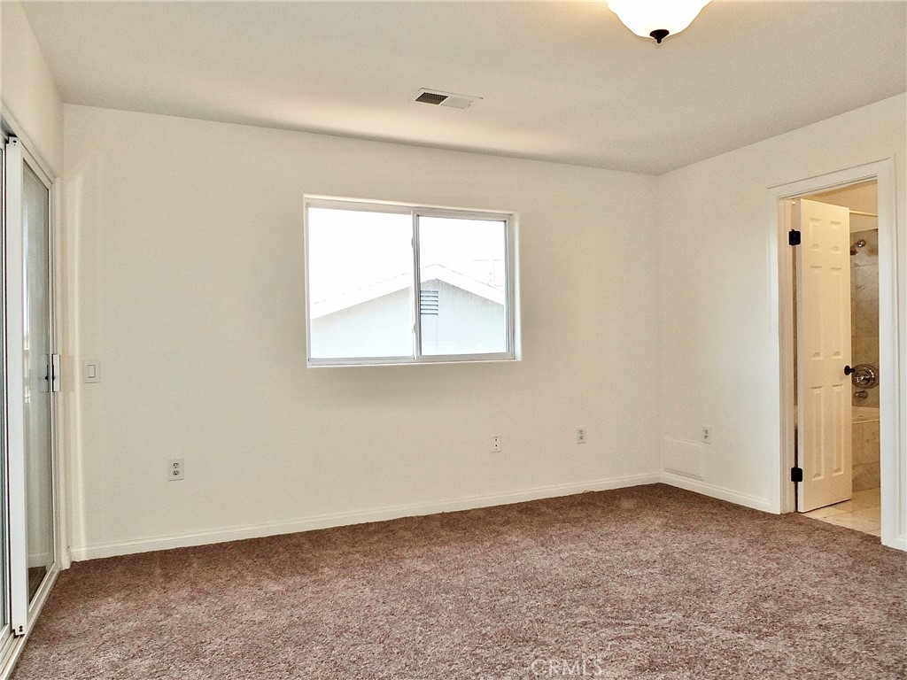 View of primary bedroom with door leading to primary bathroom - 4441 Farquhar, Los Alamitos CA 90720 - photo 29