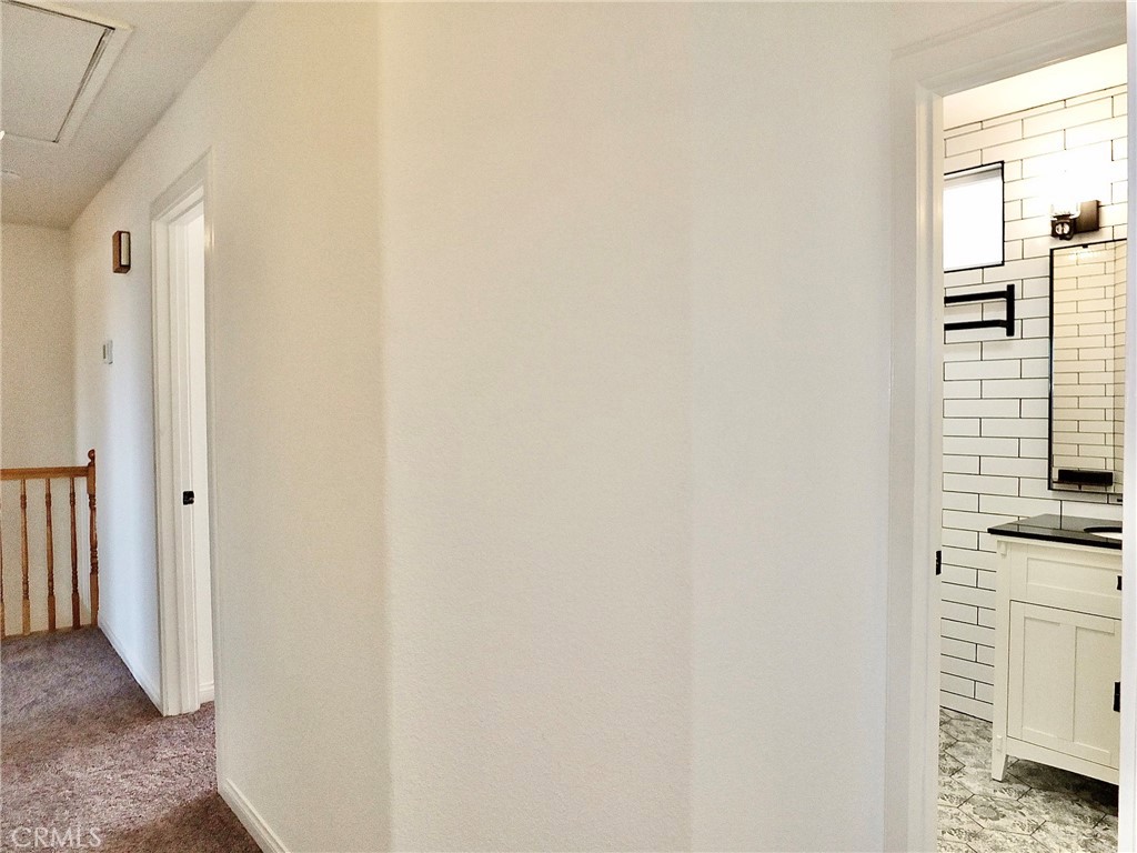 View from bedroom looking into hallway with pulldown ladder leading to attic and upstairs tiled bathroom. - 4441 Farquhar, Los Alamitos CA 90720 - photo 39