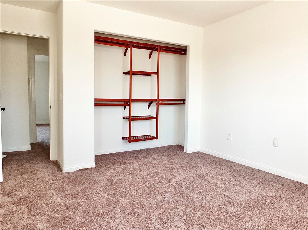 view of closet, new carpeting looking out to hallway and primary bedroom. - 4441 Farquhar, Los Alamitos CA 90720 - photo 47