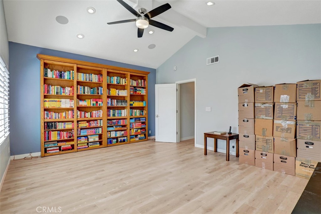 Family room bookcase opens and there is a closet the full length of the bookcase behind. - 5021 Apollo Circle, Los Alamitos CA 90720 - photo 21