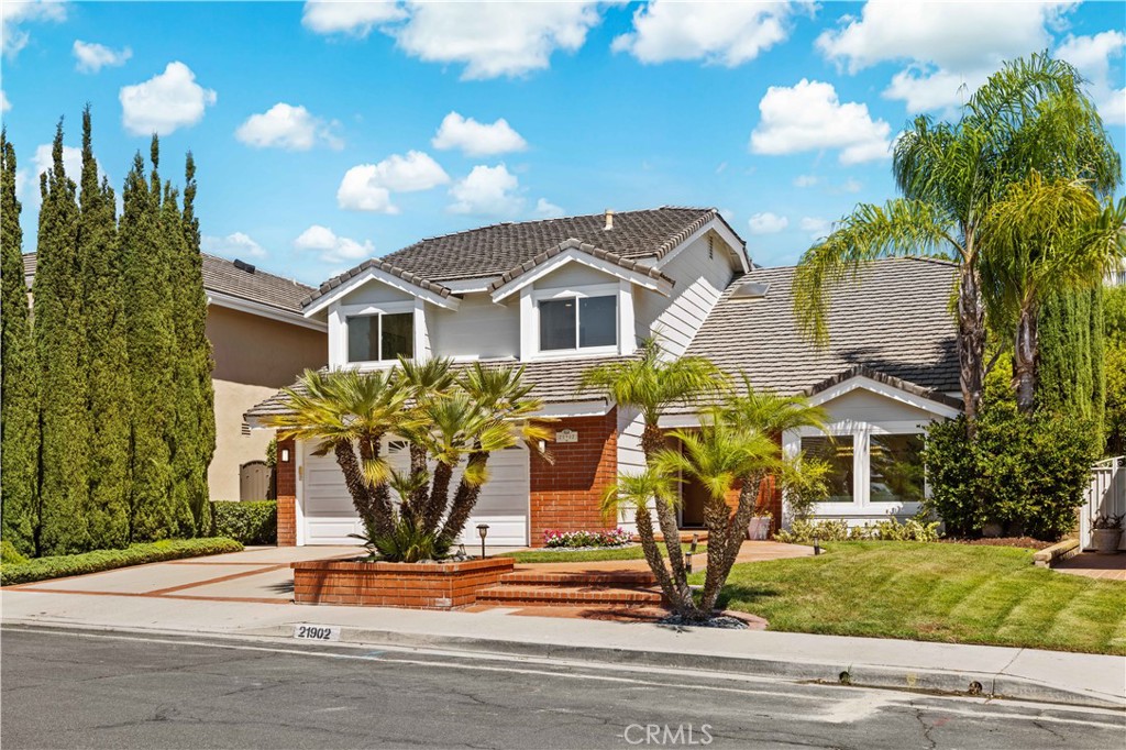 The front view showcases the well-maintained exterior and landscaping, with a clear view of the driveway and inviting fr - 21902 Herencia, Mission Viejo CA 92692 - photo 1