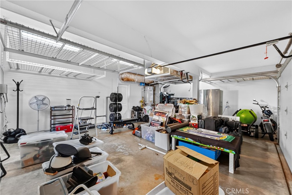 Large garage with ample drop down storage in the added ceiling shelves. - 22852 Buendia, Mission Viejo CA 92691 - photo 50