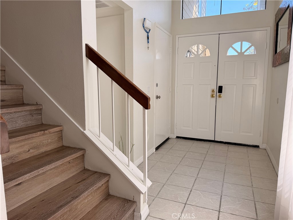 Entry foyer is tiled with nice wood laminate at stairs. - 23431 Via Linda D-or-#65, Mission Viejo CA 92691 - photo 8