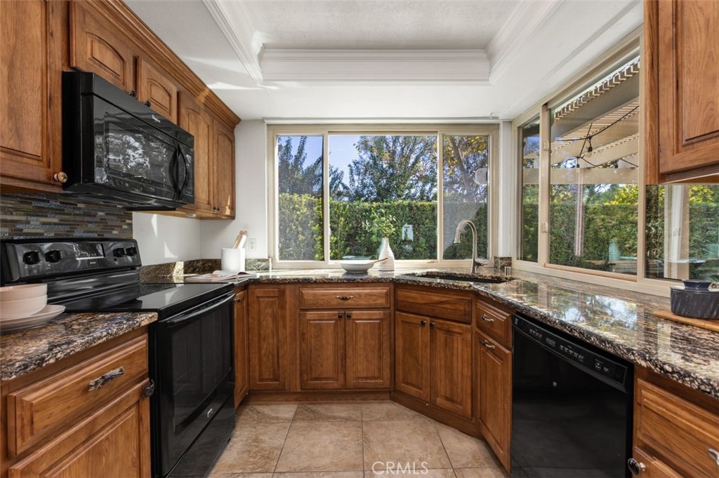 The kitchen includes granite counters and has plenty of natural light as you overlook the backyard. - 24832 El Cortijo, Mission Viejo CA 92691 - photo 10