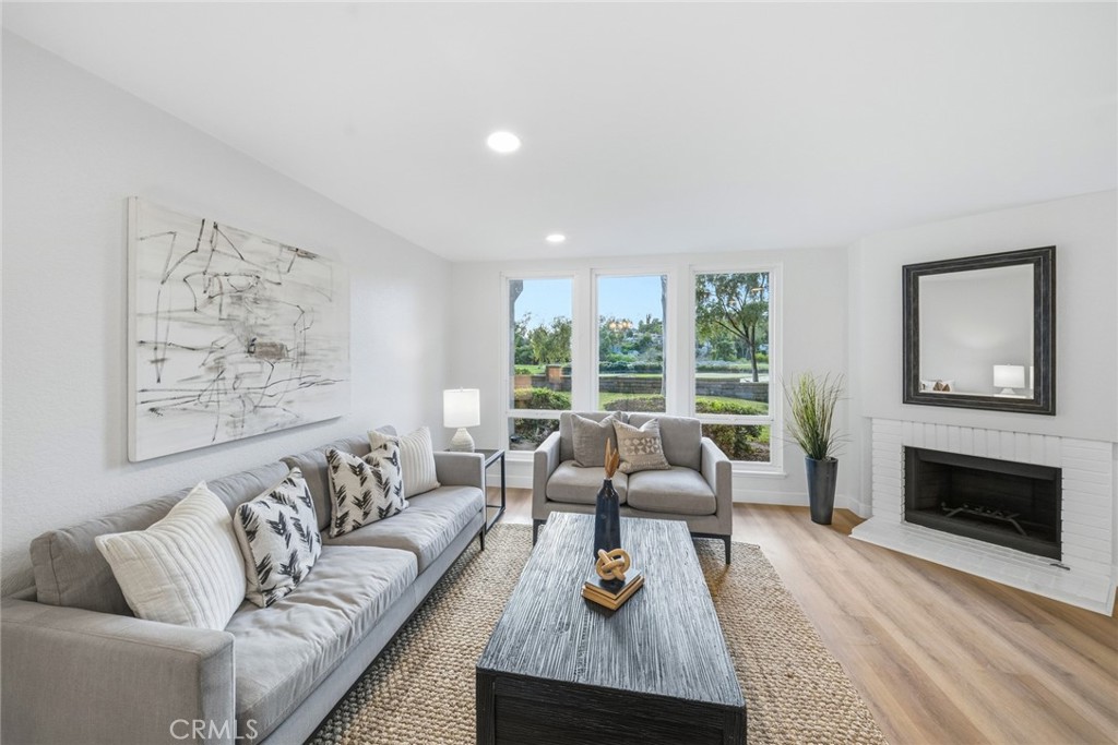 Living room with fireplace, recessed lighting and large windows. - 25911 Blascos 102, Mission Viejo CA 92691 - photo 7