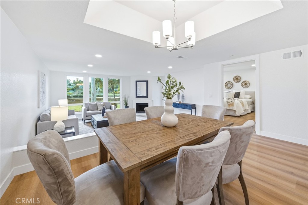 Dining area with wood table, chandelier and windows to the greenery. - 25911 Blascos 102, Mission Viejo CA 92691 - photo 12