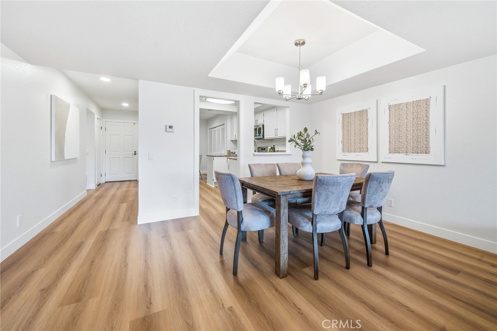 Dining area with tray ceiling and chandelier, view toward the kitchen and entry. - 25911 Blascos 102, Mission Viejo CA 92691 - photo 13