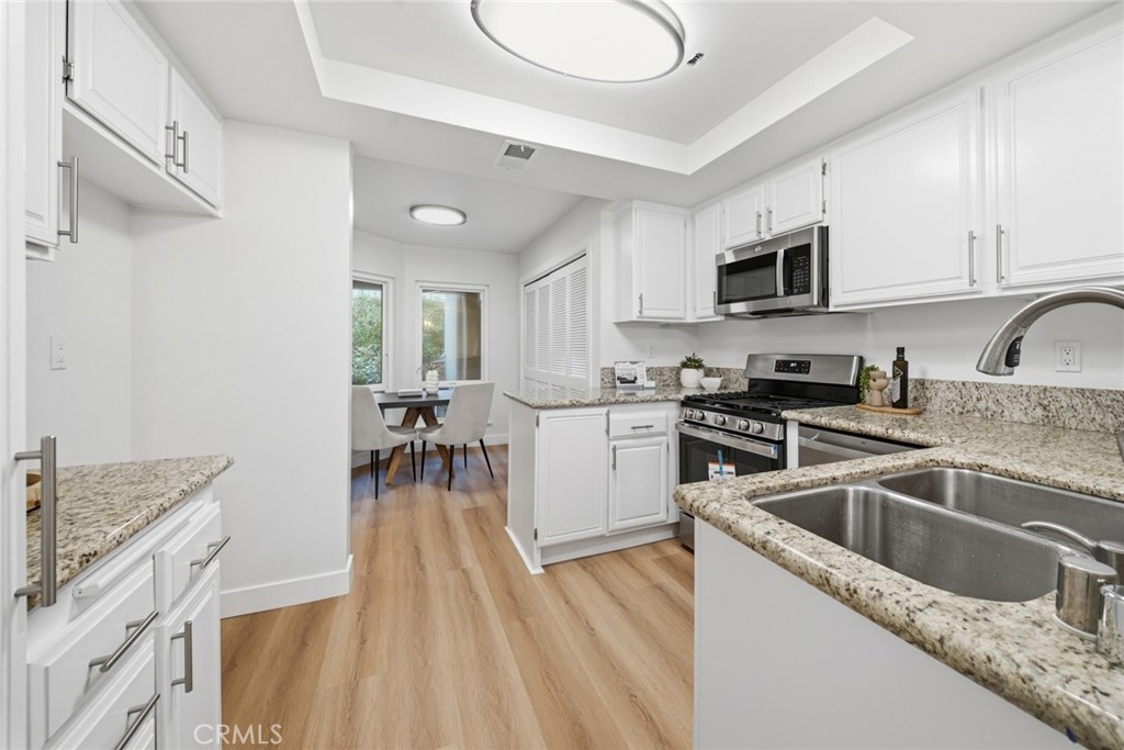 Kitchen with stainless range, double sink and tray ceiling. - 25911 Blascos 102, Mission Viejo CA 92691 - photo 15