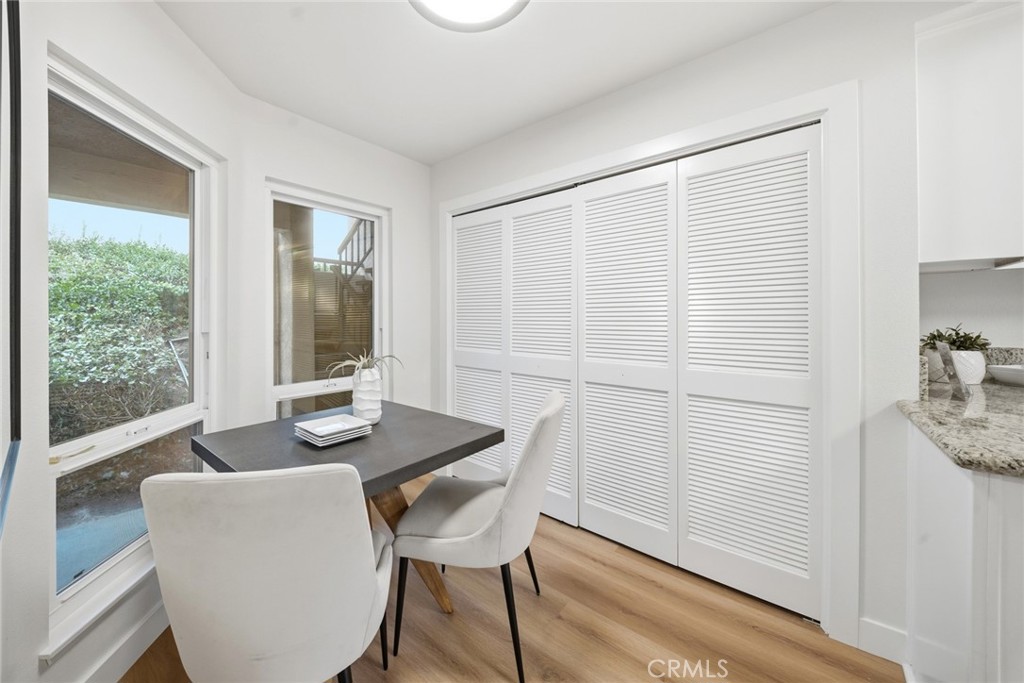 Breakfast room with windows to the greenery and white louvered closet doors. - 25911 Blascos 102, Mission Viejo CA 92691 - photo 18