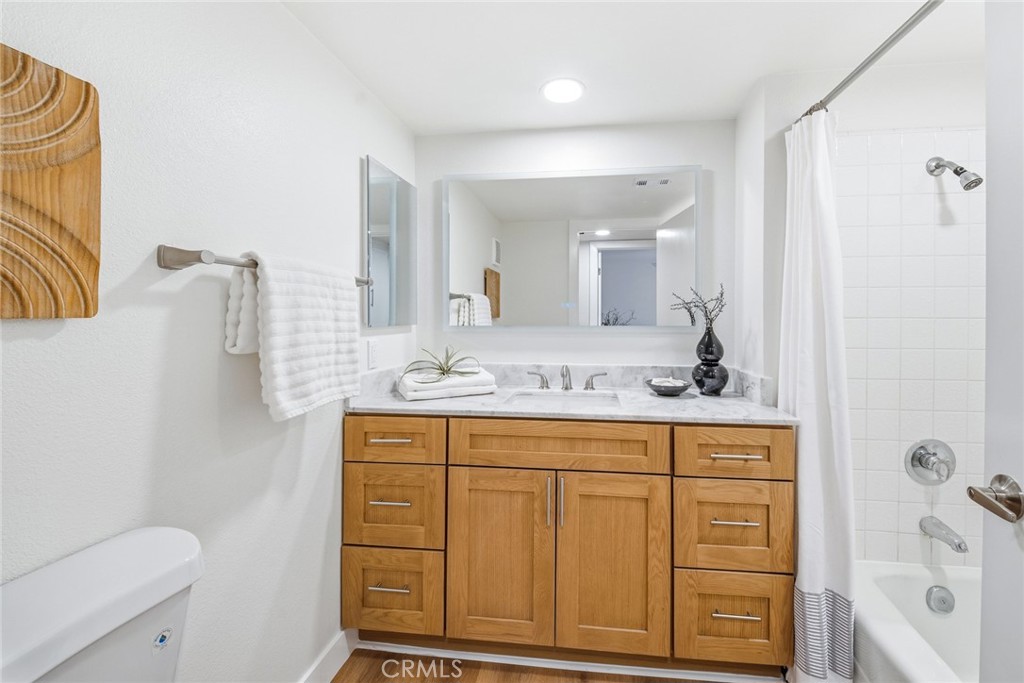 Bathroom with wood vanity and tub/shower with tile surround. - 25911 Blascos 102, Mission Viejo CA 92691 - photo 23