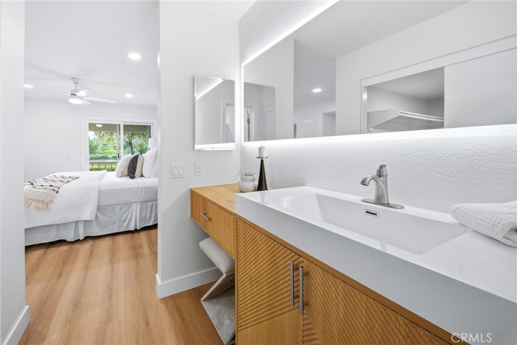 Bathroom vanity with backlit mirror, view toward the bedroom. - 25911 Blascos 102, Mission Viejo CA 92691 - photo 27