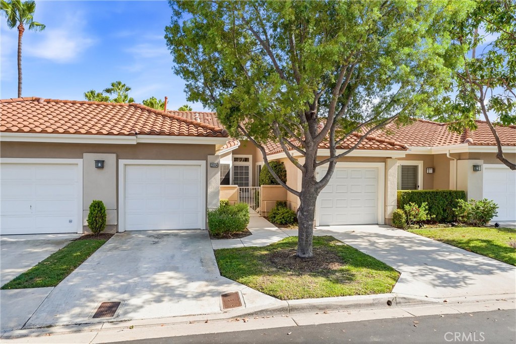 A welcoming front approach pairs two single-car garages with a courtyard entry, mature landscaping, and a walkway leadin - 28934 Paseo Picasso, Mission Viejo CA 92692 - photo 1