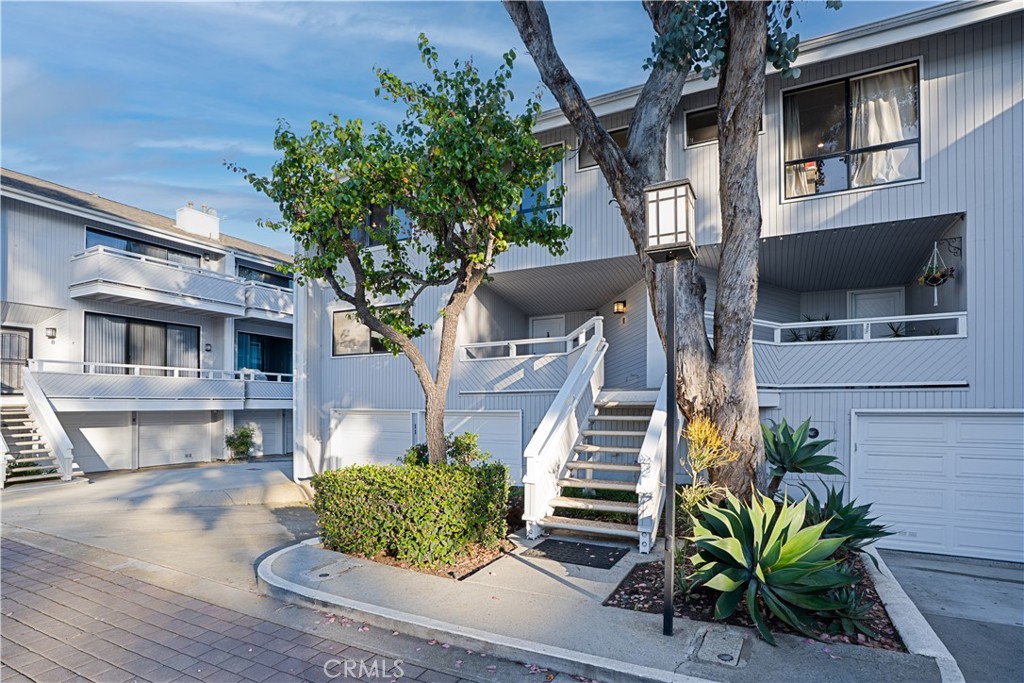 Exterior view of the home featuring a private entry, attached garage, and a quiet interior location within the community - 11 Mojo Court, Newport Beach CA 92663 - photo 1