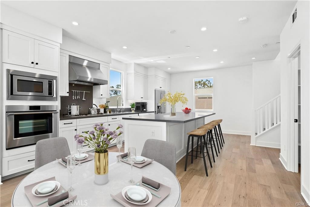 A large "eat at" island with room for at lease 4 bar stools, the flooring is the luxury vinyl, there is a built in micro - 1171 Winslow Lane, Newport Beach CA 92660 - photo 5