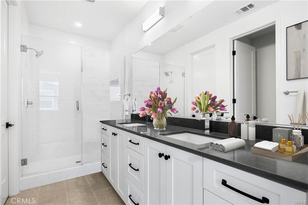Spacious primary bathroom with 2 sinks, a walk-in shower, and lots of countertop & storage space. - 1171 Winslow Lane, Newport Beach CA 92660 - photo 12