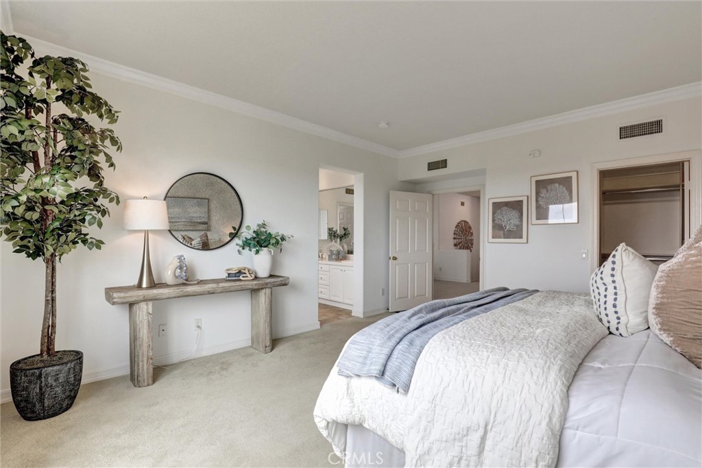 The spacious primary suite features a walk-in closet and a private ensuite bathroom, creating a comfortable and relaxing - 1402 Sea Ridge Drive, Newport Beach CA 92660 - photo 20