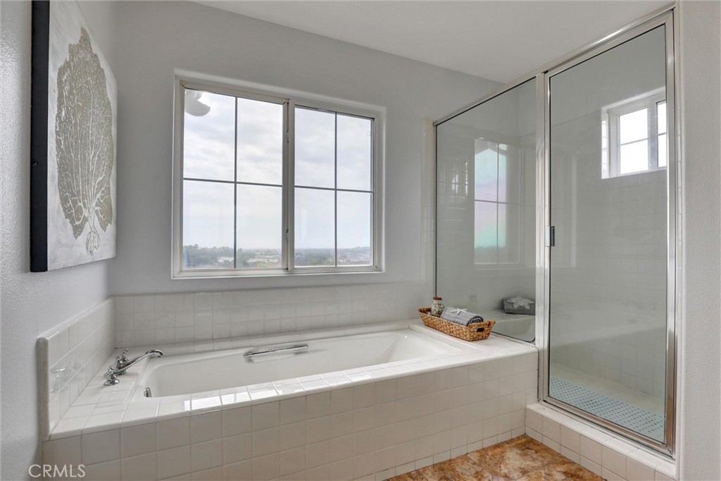 Natural light and panoramic coastal views enhance the spacious primary bathroom with its dual vanities, soaking tub, and - 1402 Sea Ridge Drive, Newport Beach CA 92660 - photo 26