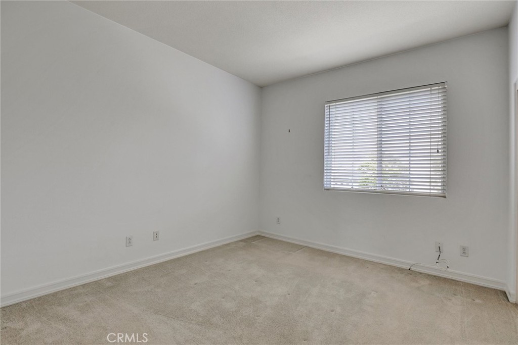A comfortable secondary bedroom with abundant natural light and generous closet space. - 1402 Sea Ridge Drive, Newport Beach CA 92660 - photo 28