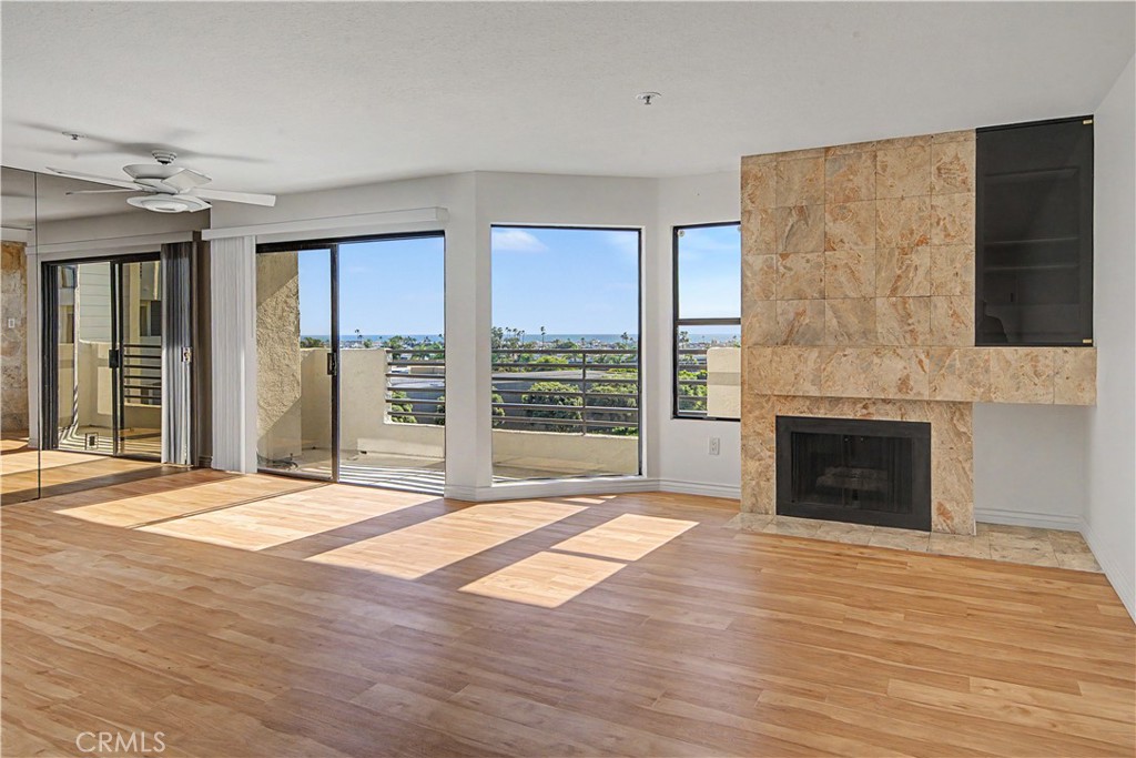 Ocean view living room with gas fireplace. - 280 Cagney Lane 207, Newport Beach CA 92663 - photo 2