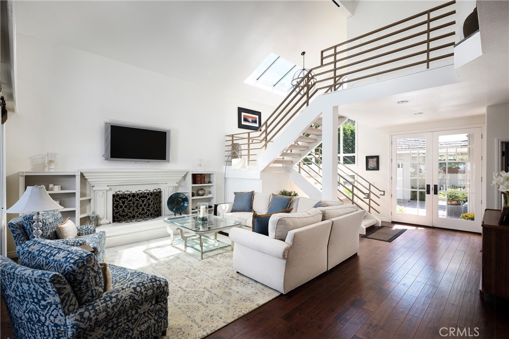 Living Room: Bright, open living room features a soaring ceiling, skylight, rich wood flooring, fireplace with built-in - 36 Vienna, Newport Beach CA 92660 - photo 5