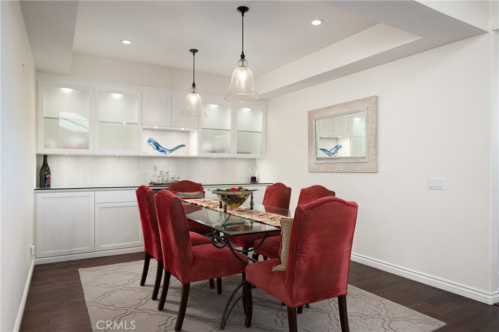 Dining Room: Dedicated dining area features pendant lighting, rich wood flooring, and extensive built-in cabinetry with - 36 Vienna, Newport Beach CA 92660 - photo 6