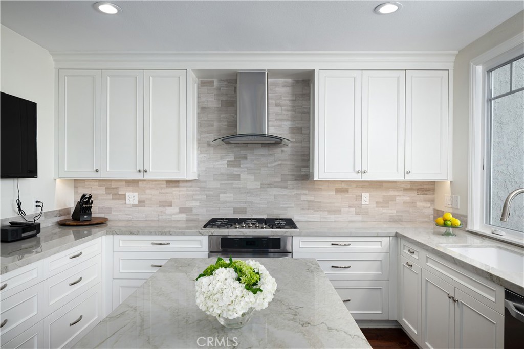 Kitchen: Another view highlights the kitchen’s generous cabinetry and counter space, stainless steel cooktop and hood, u - 36 Vienna, Newport Beach CA 92660 - photo 8