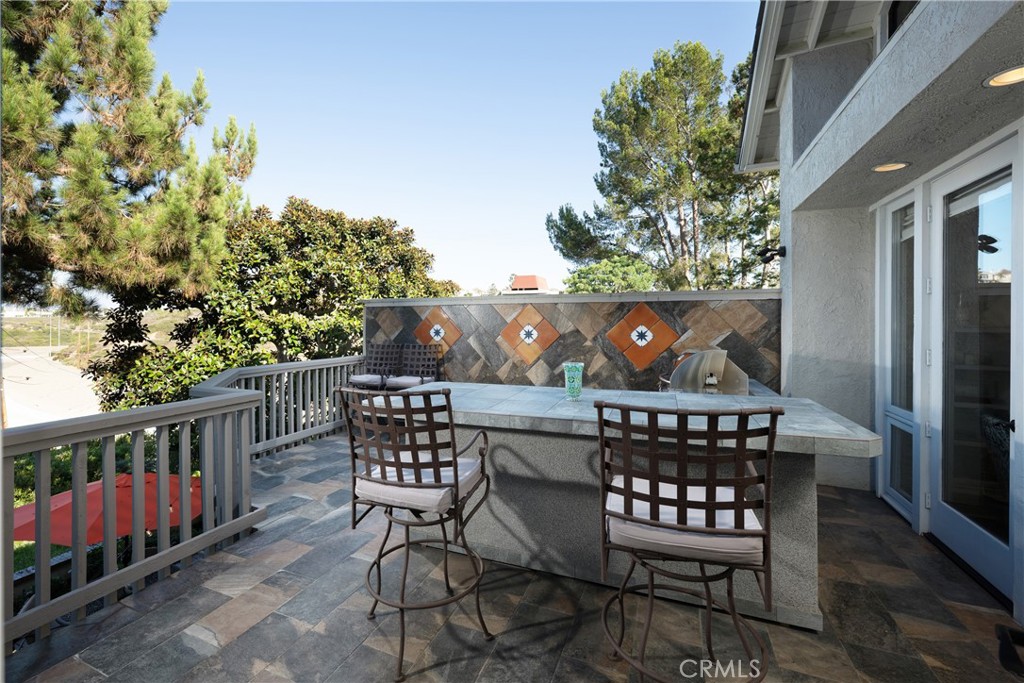 Outdoor Deck: Elevated deck offers an outdoor entertaining area with built-in counter seating and a grill, complemented - 36 Vienna, Newport Beach CA 92660 - photo 9
