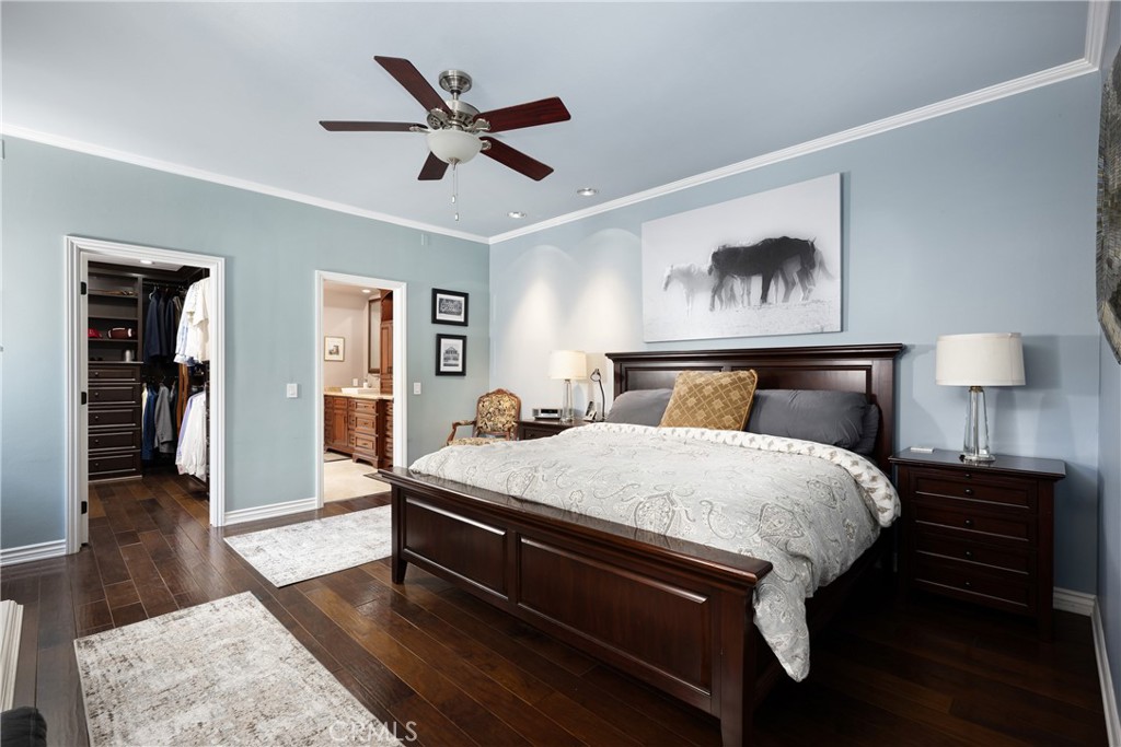 Primary Bedroom: Spacious primary bedroom features rich wood flooring, crown molding, recessed lighting, and a ceiling f - 36 Vienna, Newport Beach CA 92660 - photo 16