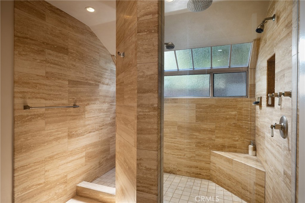 Primary Shower: Generously sized walk-in shower is finished in floor-to-ceiling stone tile and features multiple showerh - 36 Vienna, Newport Beach CA 92660 - photo 20