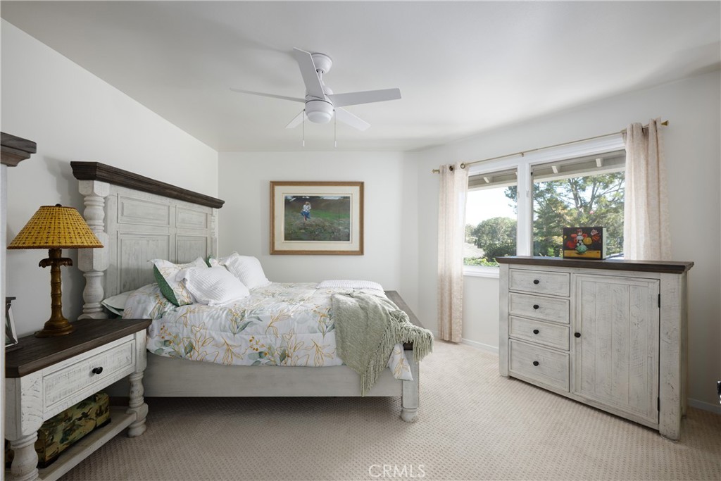 Bedroom: Bright bedroom features a ceiling fan, neutral carpeting, and a large window that brings in abundant natural li - 36 Vienna, Newport Beach CA 92660 - photo 26