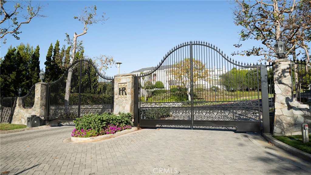 Community Entrance: A closer view showcases the ornate gated entry with stonework, decorative iron detailing, and colorf - 36 Vienna, Newport Beach CA 92660 - photo 44