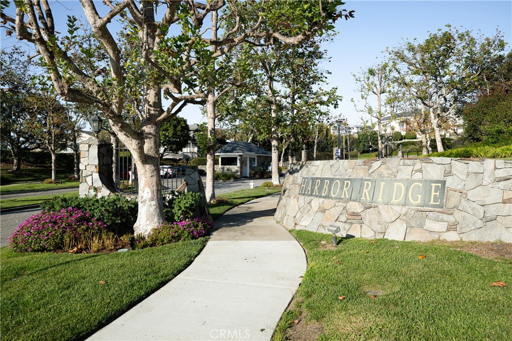 Harbor Ridge Entrance: Community signage is set within a stone wall amid mature trees and colorful landscaping, with a p - 36 Vienna, Newport Beach CA 92660 - photo 46
